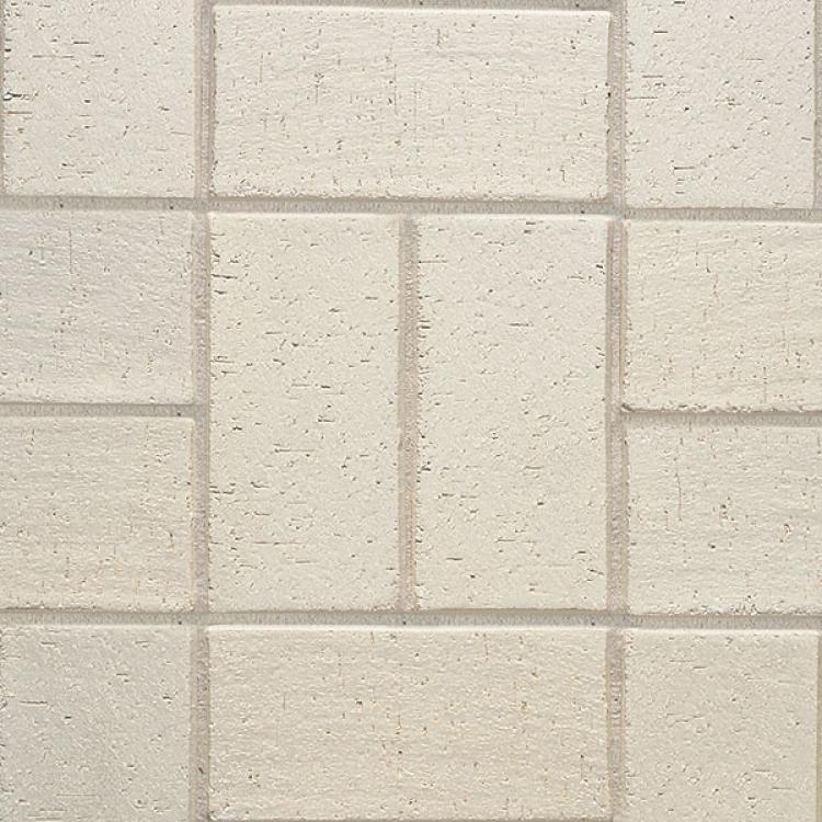 Beigefarbene Ziegelwand mit rechteckigem Muster.