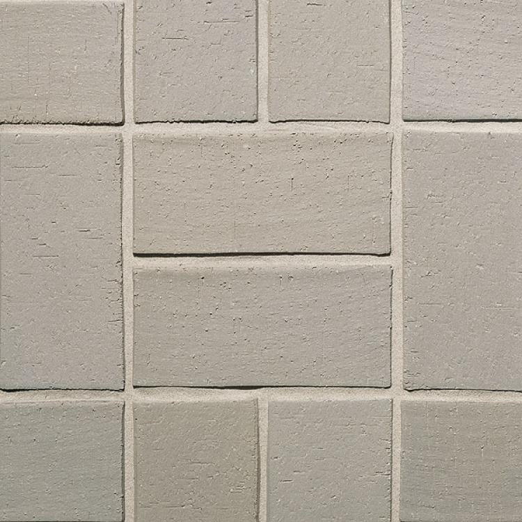 Graue Wandfliesen in einem regelmäßigen Muster.