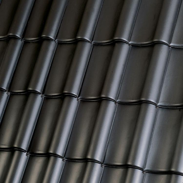 Schwarze Ziegeln in Reihen auf einem Dach.
