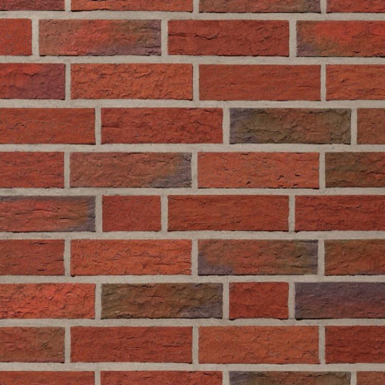 Rote Ziegelwand mit unregelmäßigen Fugen.