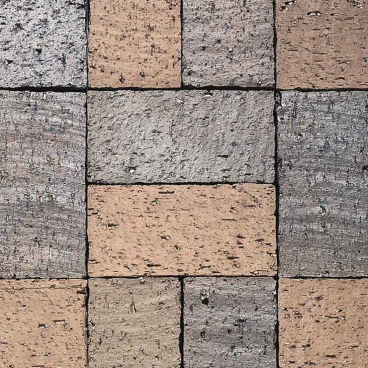 Klinkermuster aus grauen und beigefarbenen Steinen in quadratischer Anordnung.