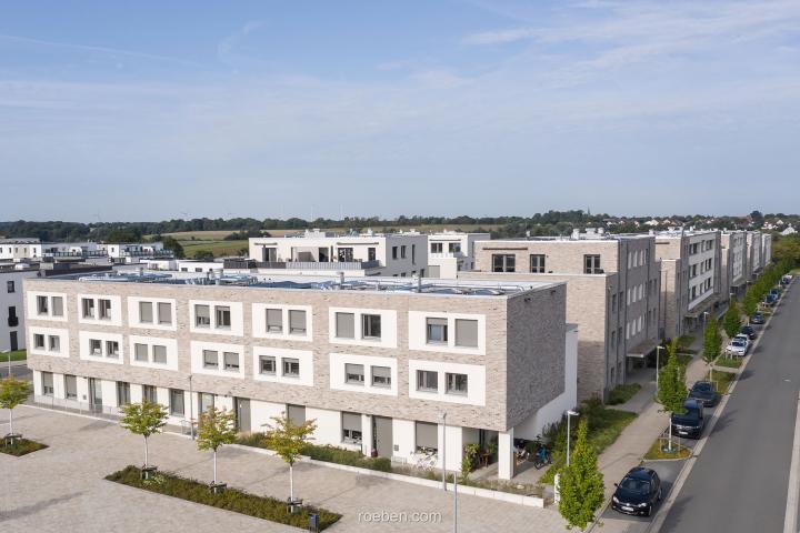 Kleekamp - Moderne Wohnsiedlung mit Reihenhäusern und Straße bei sonnigem Wetter.