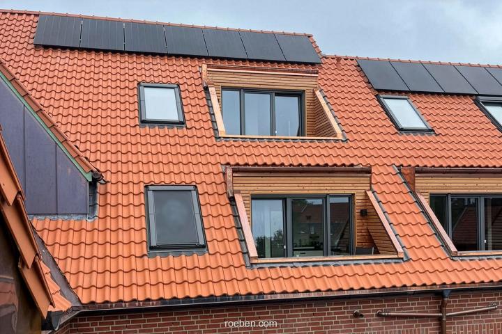 Rotes Ziegeldach LIMBURG rot-engobiert mit Solarpanelen und Dachfenstern.