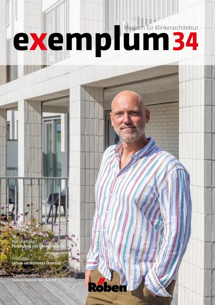 Mann in gestreiftem Hemd vor modernem Gebäude.