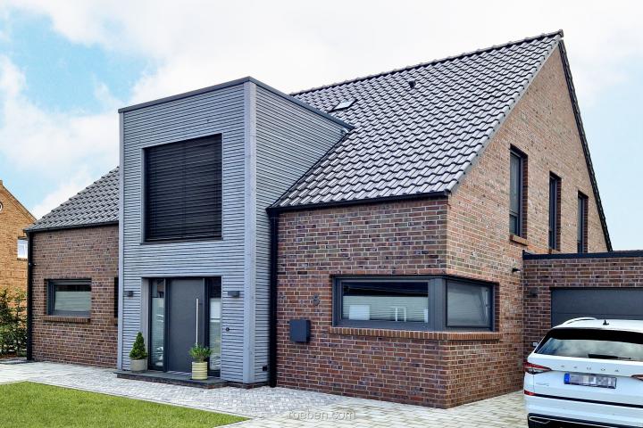 Modernes Ziegelhaus, blauer Himmel im Hintergrund.