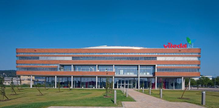 Markanter Blickfang des Gebäudes ist seine elegant detaillierte Außenhülle aus Glas und roten Keramik-Klinkerriemchen, die sich abwechselnd in lang gestreckten horizontalen Bändern um die Fassade wickeln.