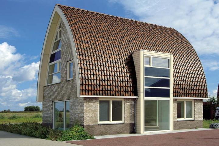 Eine nuancierte Engobe mit sanftem Glanz (FLANDERN kupferbraun-nuanciert) und die außergewöhnliche Dachform machen den Reiz dieses Einfamilienhauses aus.