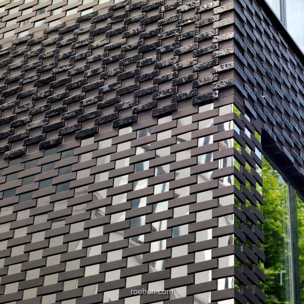 Urban Mesh Design, London: FARO schwarz nuanciert Die glatten FARO-Klinker wurden im Wechsel im Läuferverband mit Steinen gemauert, die mit polierten Edelstahlplatten beklebt wurden