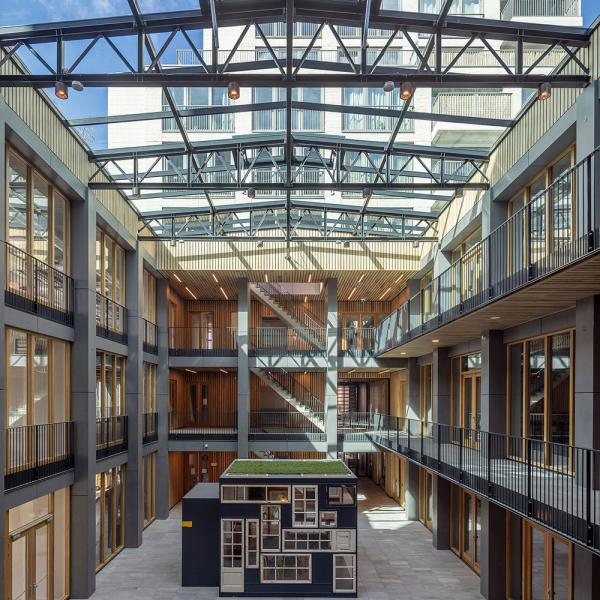 Moderne Glas-Stahl-Architektur mit Innenhof und blauem Himmel.