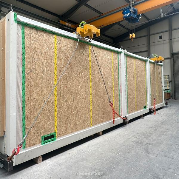 Modulbau in Fabrikhalle, an Kran gehängt.