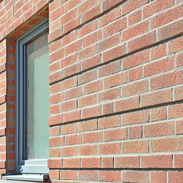 Relief aus 14 und 25 mm-Klinkerriemchen mit zwei Fenstern.