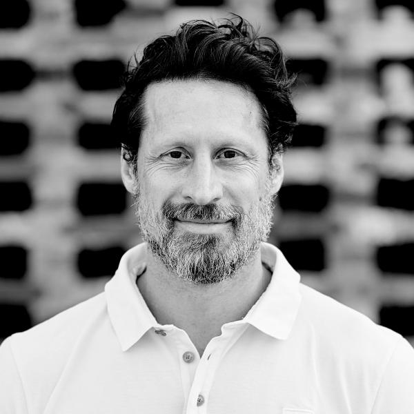 Philipp Seidel mit Bart in weißem Hemd, schwarz-weiß Fotografie.