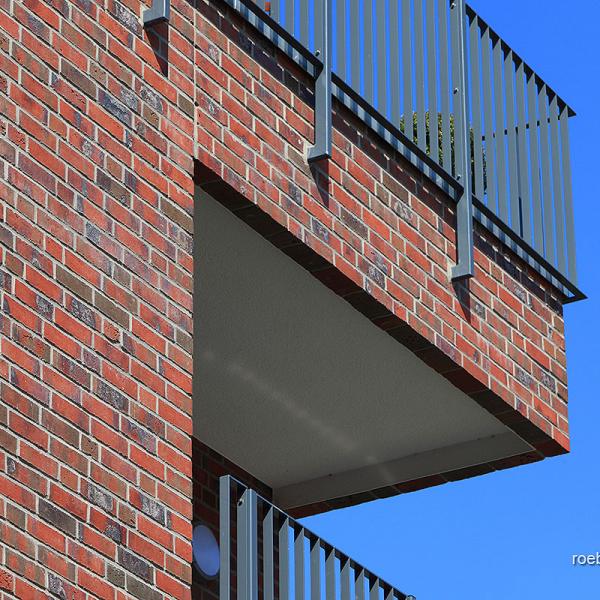 An den Balkonplatten wurden Röben Ziegelfertigteile (3 Läuferschichten) montiert, darauf konventionell gemauert. Die Geländer sind an der Betonplatte befestigt. | Foto: Ulrich Wozniak