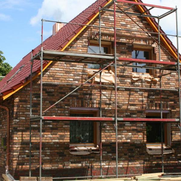 Der Dachüberstand wurde angepasst, das Dach neu gedämmt und die Röben-Tondachziegel FLANDERNplus cayenne verlegt. Der Anbau hinten ist als solcher nicht mehr zu erkennen.