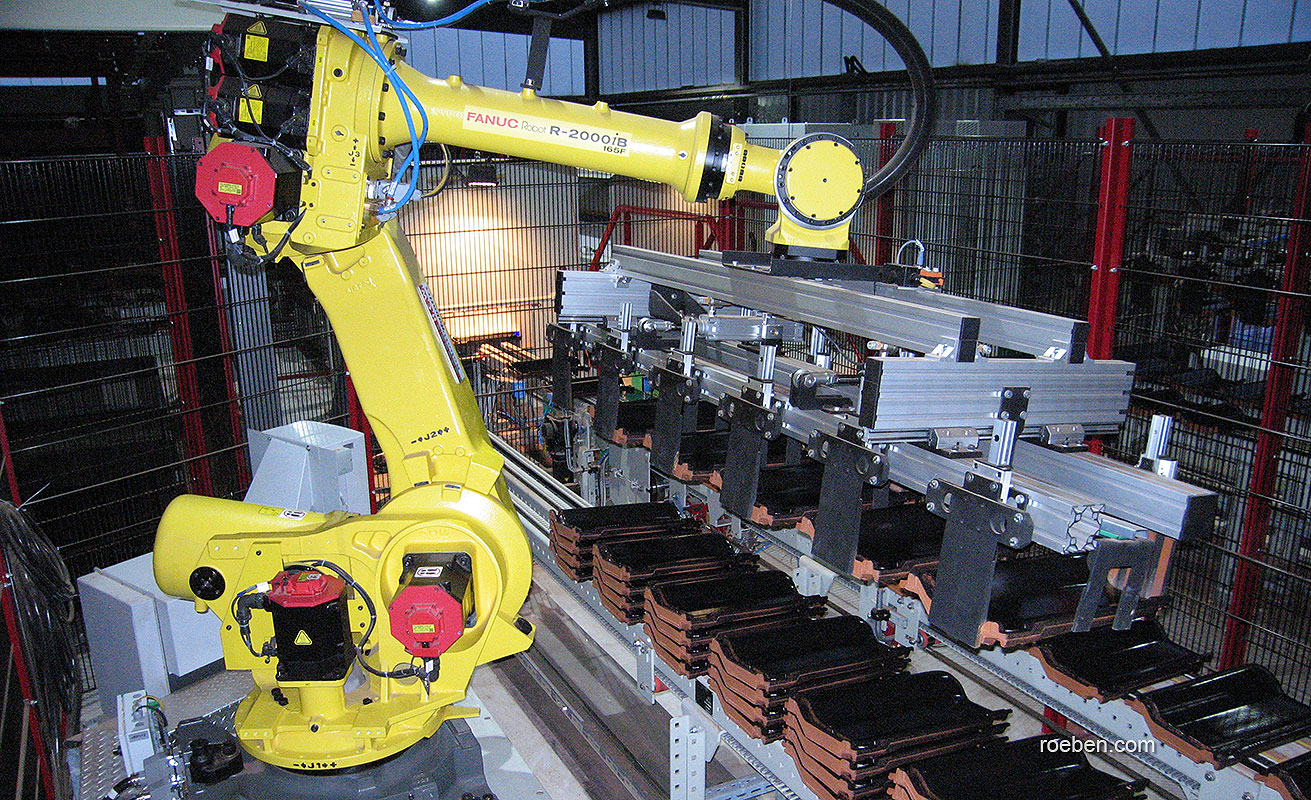 Industrieroboter in Fabrikhalle, gelb und metallisch.
